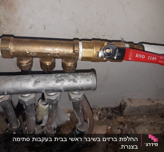 ברז פליז עם ידית אדומה וצינורות מתכת